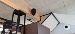 Enceintes Void Acoustics sur poutre dans un bar — installation sonorisation Design Audio