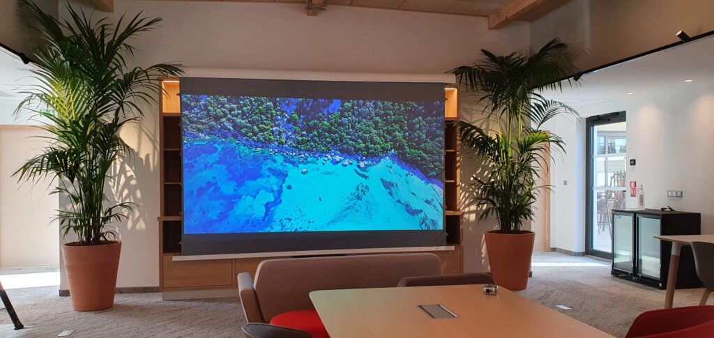 Grand écran Xtrem Screen et vidéoprojection dans un espace de réception d'hôtel — installation Design Audio